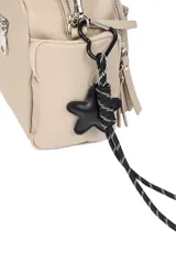 Bandolera color beige con textura de cuero, correa ajustable de tela negra y detalles metálicos plateados. Cuenta con múltiples bolsillos con cierre, incluyendo dos frontales y uno trasero, y un llavero decorativo de estrella con cordón.
