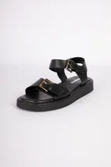 Sandalias negras de cuero sintético con agarre en tobillo y empeine, ambos con hebillas metálicas ajustables color dorado. Cuentan con una plataforma de 3cm.