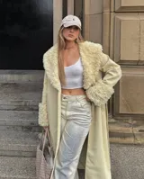 Abrigo trench maxi color beige con ribete de piel sintética en cuello y puños.