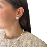 Par de aros pequeños plateados con forma de argolla triple con incrustaciones de zirconia.