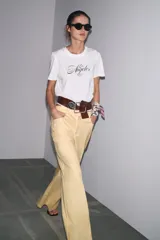 Camiseta blanca de cuello redondo y manga corta con estampado de texto en azul.