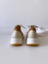 Zapatillas de cuero en tonos lila y beige, con cordones y suela de goma.