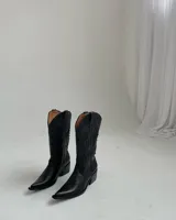 Bota texana de cuero negro con bordados en el empeine y caña media.