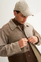 Camisa de hombre estilo leñadora con diseño patchwork en tonos beige y marrón. Presenta coderas, cartera americana y bolsillo ojal en el delantero. Confeccionada en lana fina sin teñir.