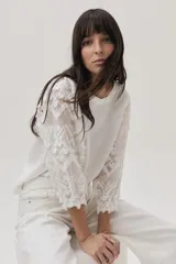 Blusa blanca de lino con mangas 3/4 con detalles de encaje.