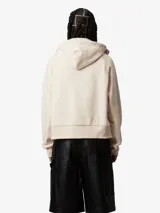 Campera negra con capucha ajustable, cierre frontal con cremallera, bolsillo tipo canguro con remaches metálicos y logo cuadrado en el frente.