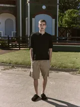 Polo negro de manga corta con cuello clásico y cierre de dos botones. Tejido de punto plano con textura ligera y fit relajado.