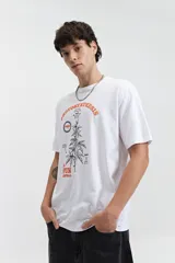 Remera verde con estampado de planta de marihuana y texto en color celeste.