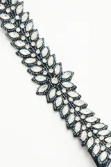 Vincha elástica negra bordada con diseño de flor, piedras, strass y mostacillas.