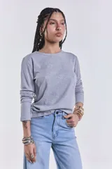 Remera gris de manga larga con cuello redondo y corte clásico.