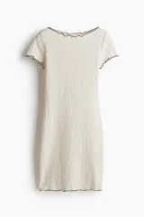 Vestido corto color crudo, de punto con efecto arrugado y ribetes sobrehilados negros en cuello y mangas.
