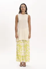 Pantalón palazzo de tejido de punto color amarillo con estampado de hojas blancas.