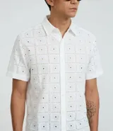 Camisa blanca de algodón con bordado de flores, corte regular, cuello inglés, manga corta y abotonadura frontal.