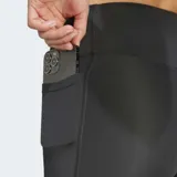 Calza corta deportiva Adidas color negro, de tiro alto y ajuste ceñido. Presenta un pequeño logo de tres barras en blanco en el muslo y un bolsillo oculto lateral.