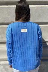 Sweater negro de tejido de punto con escote en V y rayas verticales plateadas.