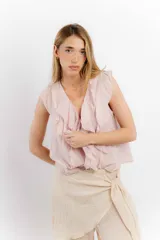 Blusa blanca de algodón con escote en V, volados en el frente y mangas cortas.