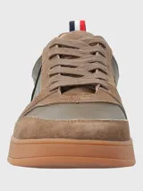 Zapatillas urbanas de cuero color marrón con detalles en verde oliva, cordones marrones y suela de goma color caramelo.