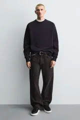 Zapatillas deportivas negras con detalle en blanco en el talón y suela blanca con volumen.