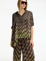 Blusa marrón con estampado abstracto, cuello camisero y botones en la parte delantera.