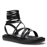Sandalias negras con plataforma plana y tiras finas que se atan alrededor del tobillo.