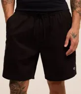 Bermuda de sarga lavada color verde claro, con lazo ajustable en la cintura, bolsillos laterales y un pequeño parche negro con logo en la pierna izquierda.