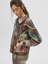 Campera rompevientos estilo biker con capucha desmontable, color celeste con estampado de nubes blancas y detalles en blanco.