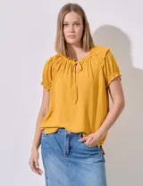 Blusa de gasa color fucsia con cuello fruncido, escote en V y lazo, ideal para combinar con jeans.