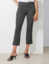 Pantalón negro con estampado geométrico blanco, de corte flare y pretina ancha elastizada.