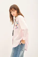 Camisa rosa claro de algodón con cuello mao, bordado a mano con detalle en el cuello, cierre frontal con botones de nácar y mangas largas.