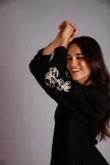 Camisa celeste de corte clásico, con botones frontales y bordados florales en las mangas.