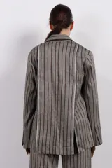 Blazer gris con rayas verticales marrones, solapas de muesca, cierre con un botón y bolsillos con solapa.