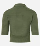Blusa de punto color crema, con cuello polo, mangas cortas y puños con botones.