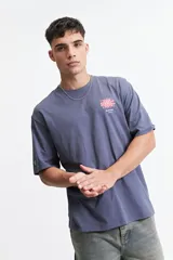 Remera oversize azul con estampado en la espalda que incluye una flor abstracta y la palabra 'blurred'.