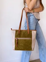 Bolso tipo tote de cuero color verde oliva con laterales de cuero texturizado color beige y manijas de cuero color marrón.
