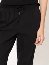 Pantalón babucha color café, confeccionado en algodón liviano, con cintura elastizada, cordón ajustable, bolsillos laterales y botamangas levemente entalladas.