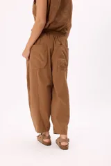 Pantalón blanco de tela ligera con cintura elastizada, calce relaxed y bolsillos laterales.