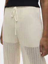 Pantalón de tiro alto con corte wide leg y cintura elástica con cordón ajustable. Confeccionado en punto single jersey con mezcla de algodón convencional, algodón reciclado y poliéster reciclado, combina suavidad, elasticidad y comodidad.