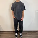 Remera gris con efecto lavado, corte oversize y estampado en la espalda con esqueleto de pez, texto y logos de la marca Underwave Brand.