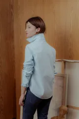 Camisa celeste de corte clásico con volados al frente y en los puños.