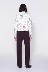 Pantalón de pana color borgoña, de corte recto, largo tobillero y tiro alto con cinco bolsillos. Cierre con cremallera y trabilla para el cinturón.