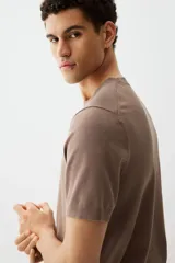 Remera marrón de punto fino, con cuello redondo y mangas cortas.