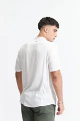 Camisa blanca de manga corta con cuello mao y doblez en las mangas.