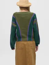 Cardigan corto de punto color verde oliva con rayas verticales en verde oscuro y lila. Tiene escote en V, mangas largas y botones al frente.