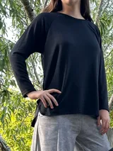 Remerón negro de manga larga, corte oversize con espalda más larga, tajos laterales y bajo redondeado.