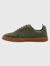 Zapatillas deportivas de cuero color blanco hueso con detalles en gamuza y suela de goma color caramelo.