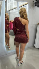 Minivestido de fiesta color bordó con lentejuelas, un hombro descubierto y manga larga abullonada.
