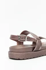 Sandalia chunky de material sintético color nude, con dos tiras anchas ajustables con textura acanalada y hebilla metálica en el tobillo. Posee suela elevada de goma con relieve.