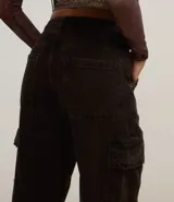 Pantalón recto de jean color negro con trabillas en la cintura, cierre con botón y cremallera, y bolsillos cargo laterales.