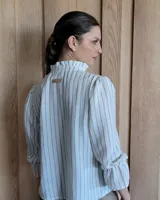 Blusa celeste con cuello mao y mangas abullonadas.