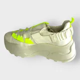 Championes blancos con plataforma, cordones y detalles en amarillo neón.